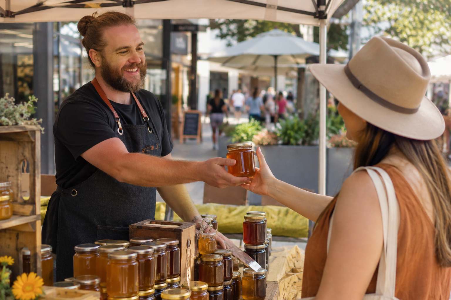 Vendor handing a jar of Gold Coast honey to a customer at a market stall